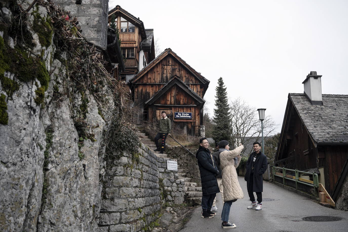 Hallstatt era hace diez años una villa idílica al borde de un lago de ensueño y aún lo sigue siendo, pero de otra manera. Lo que entonces le faltaba al pequeño pueblo austriaco, ahora le sobra. Tiene gente para dar y regalar, la hay por todas partes, tanta que hasta los visitantes se cuelan sin permiso en las casas en busca de un baño que no esté ocupado. En el pueblo residen 778 vecinos pero no lo parece porque apenas se les ve. Su presencia se diluye ante las riadas de personas que transitan por las calles en busca de un lugar vacío donde sacarse una foto mientras decenas de drones sobrevuelan los tejados para obtener imágenes impactantes. Hay turistas que llegan a la localidad convencidos de que se encuentran en un parque temático donde todo es de cartón piedra y todo está a la venta. Otros creen que están recorriendo el auténtico Arendelle, el reino de la película 'Frozen'. Hallstatt es un pueblo de moda, hasta ha sido calificado como «el más 'instagrameable' del mundo», y eso está siendo su ruina.