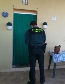 Imagen secundaria 2 - Una patrulla de Llombai (izq.) y un guardia inspecciona una de las casas asaltadas. 