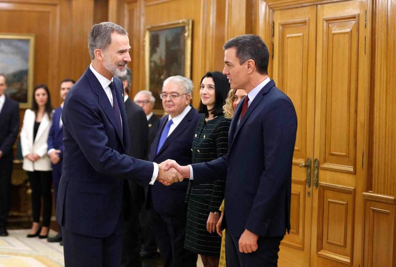 El presidente del Gobierno, Pedro Sánchez (d) saluda al rey Felipe VI (i) durante la jura de ministros de su nuevo gobierno.