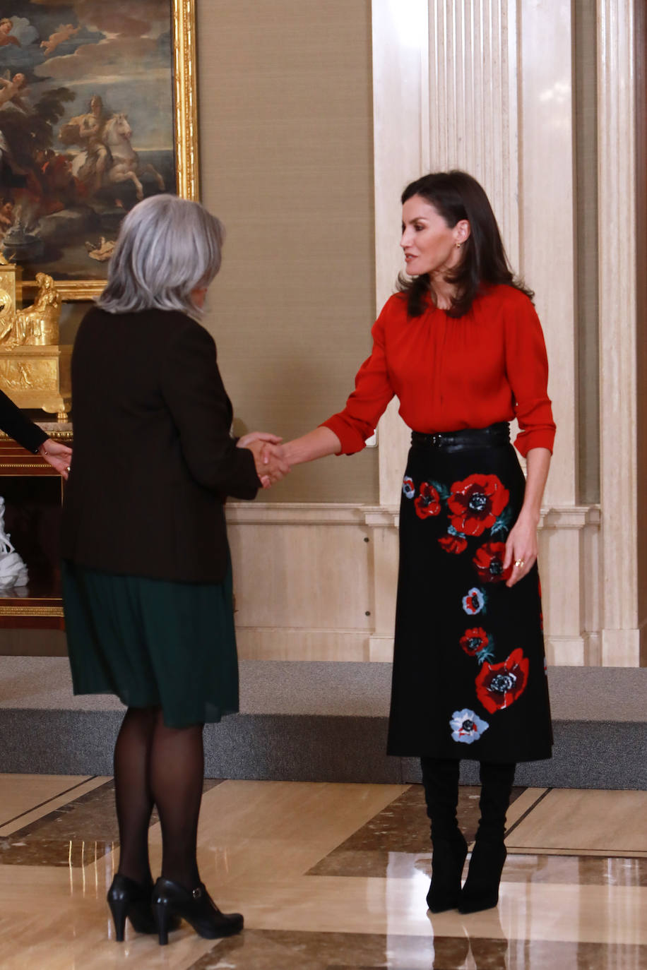 La Reina ha tenido el primer acto de su agenda oficial de esta semana, durante la mañana de este martes, recibiendo audiencias en el Palacio de la Zarzuela. Doña Letizia primero se ha reunido con FEDICINE, la Federación de Distribuidores Cinematográficos y, acto seguido, con la Fundación Mujeres. Para los actos ha optado por el mismo look recuperando antiguas piezas de su armario: una blusa roja de Hugo Boss, falda negra midi de flores estampadas de Carolina Herra combinandola con calzado alto de Magrit.