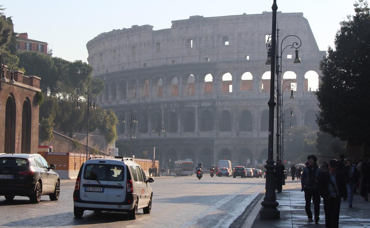 Coches circulando frente al Coliseo de Roma. 