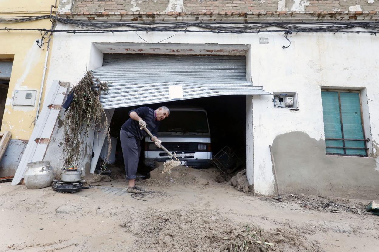 Un vecino saca el barro acumulado tras las lluvias de septiembre. 