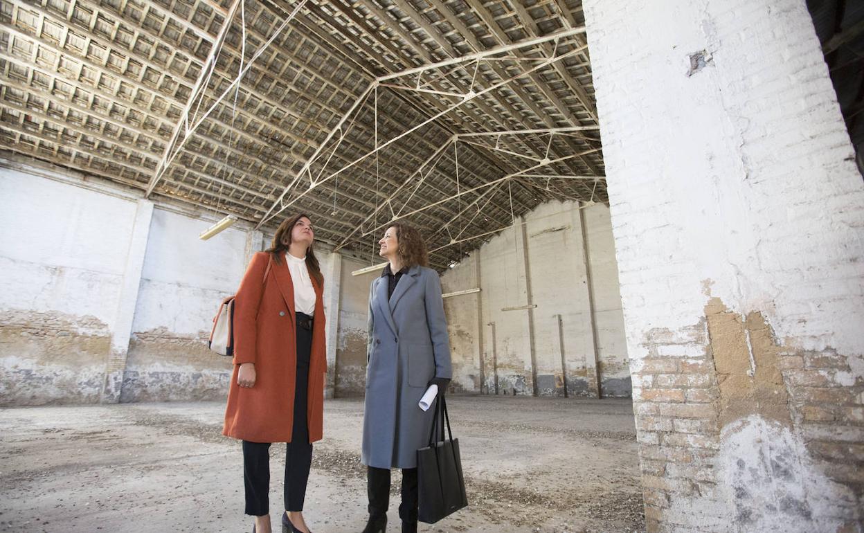 Sandra Gómez y Maite Ibáñez, ayer, en la presentación del estado actual de las naves de la calle Mariano Cuber, que se convertirán en espacio de creación escénica.