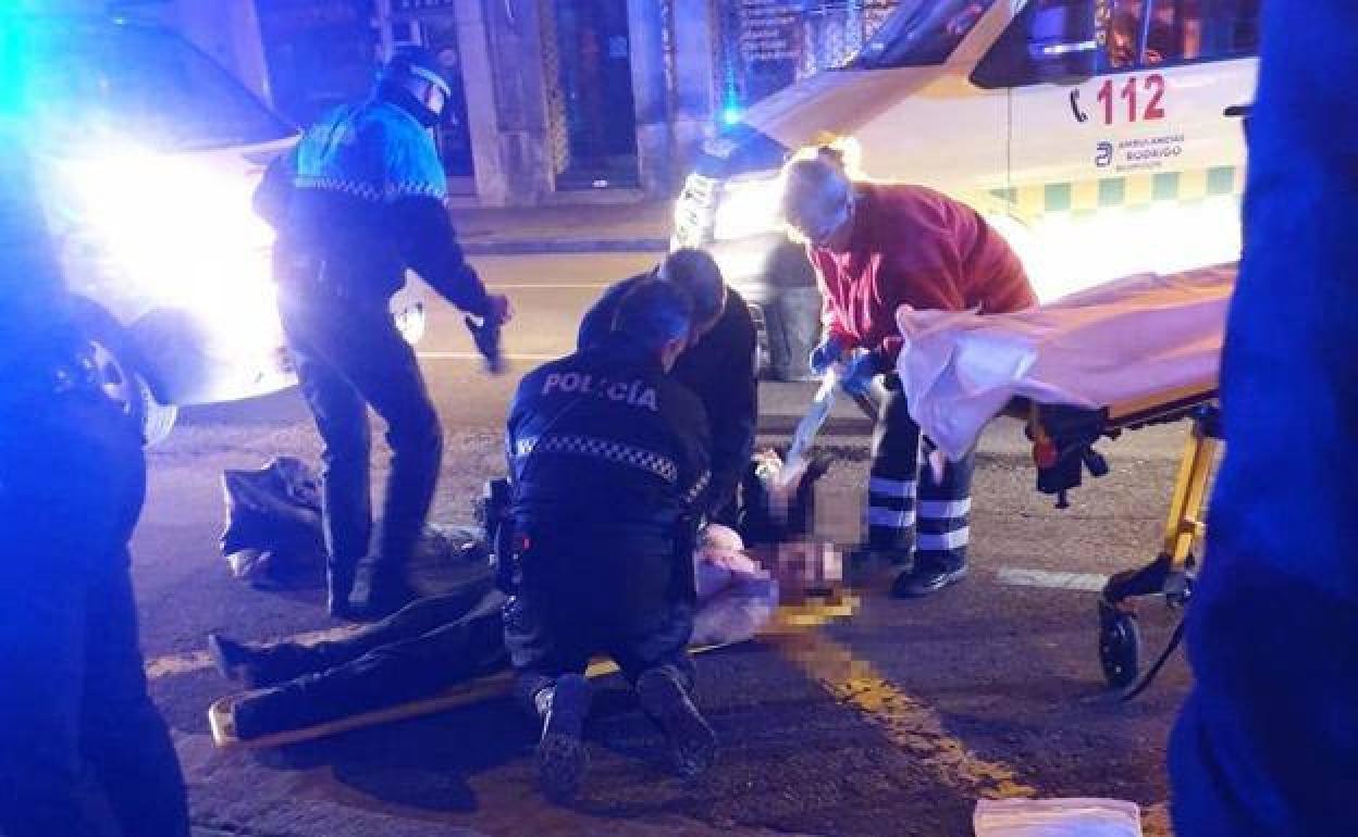 Policías y sanitarios atienden al fallecido en plena calle.