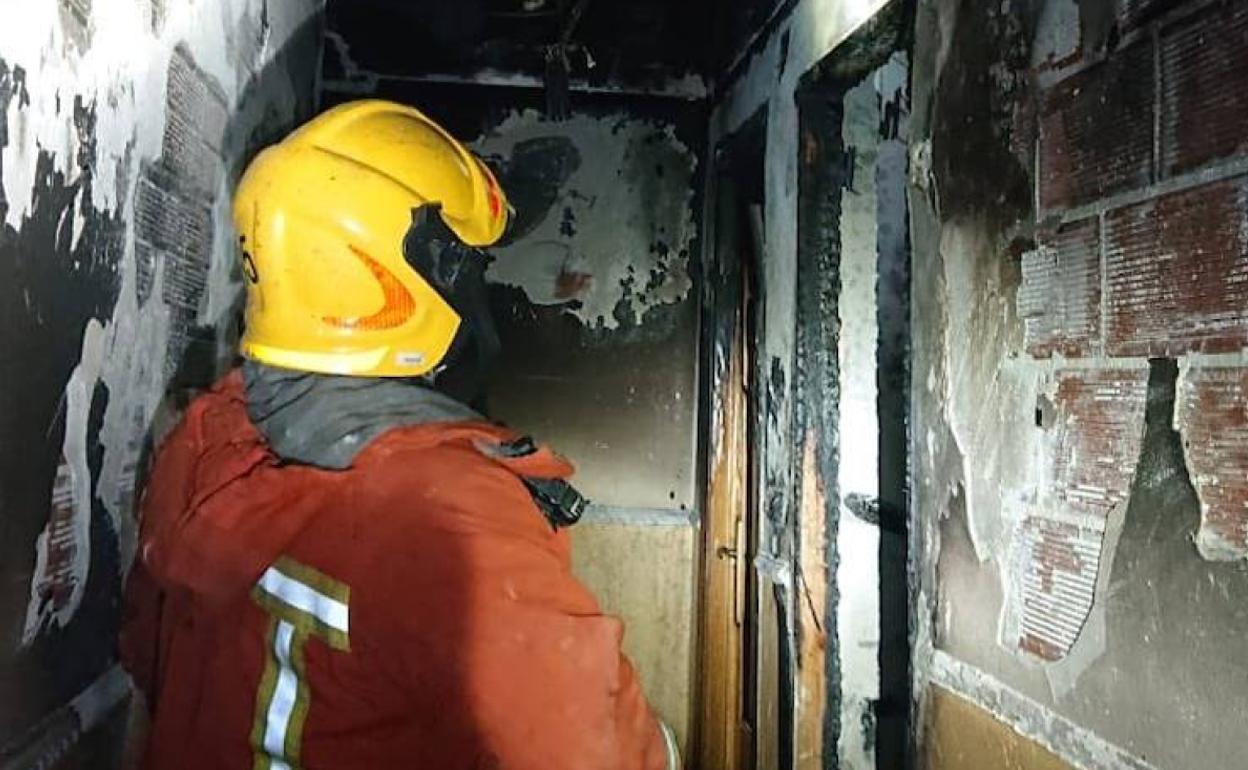 Bombero en el interior de la casa de Torrent incendiada. 