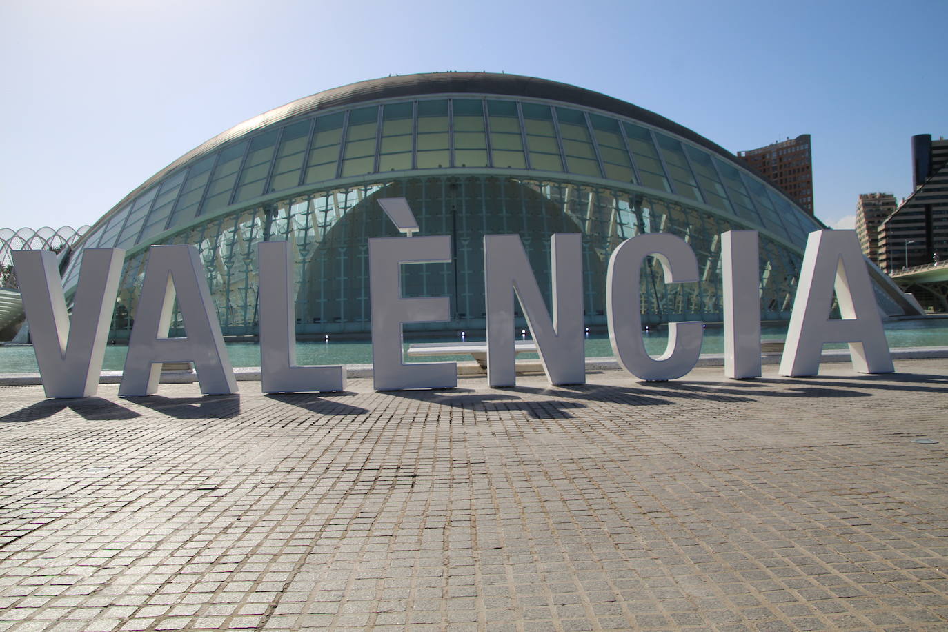 El Ayuntamiento instala las letras con el nombre de la ciudad en la parte trasera del Hemisfèric con el objetivo de sumarse a la campaña de otras ciudades. Las ocho letras mayúsculas guardan el estilo utilizado por CACSA para situar, en la parte frontal de los edificios de la Ciudad de las Artes y de las Ciencias, el nombre de cada uno de ellos. Así, la concejalía de Turismo se sumó en la pasada legislatura a seguir el ejemplo de urbes como Ámsterdam, Vitora o Gijón, entre otros, para tener un punto fotográfico en el cap i casal. La altura de cada elemento es de 1,80 metros y por las noches de iluminará con un sistema led para hacerse más llamativo. El montaje ocupa casi 11 metros de longitud y se podrían desmontar si fuera necesario, según precia el Ayuntamiento. La idea del Consistorio es aprovechar los dos millones de personas que se acercan a este enclave para sumar más presencia de la ciudad en redes sociales.