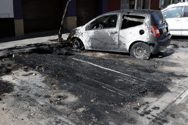 Arden tres coches en una calle de Valencia