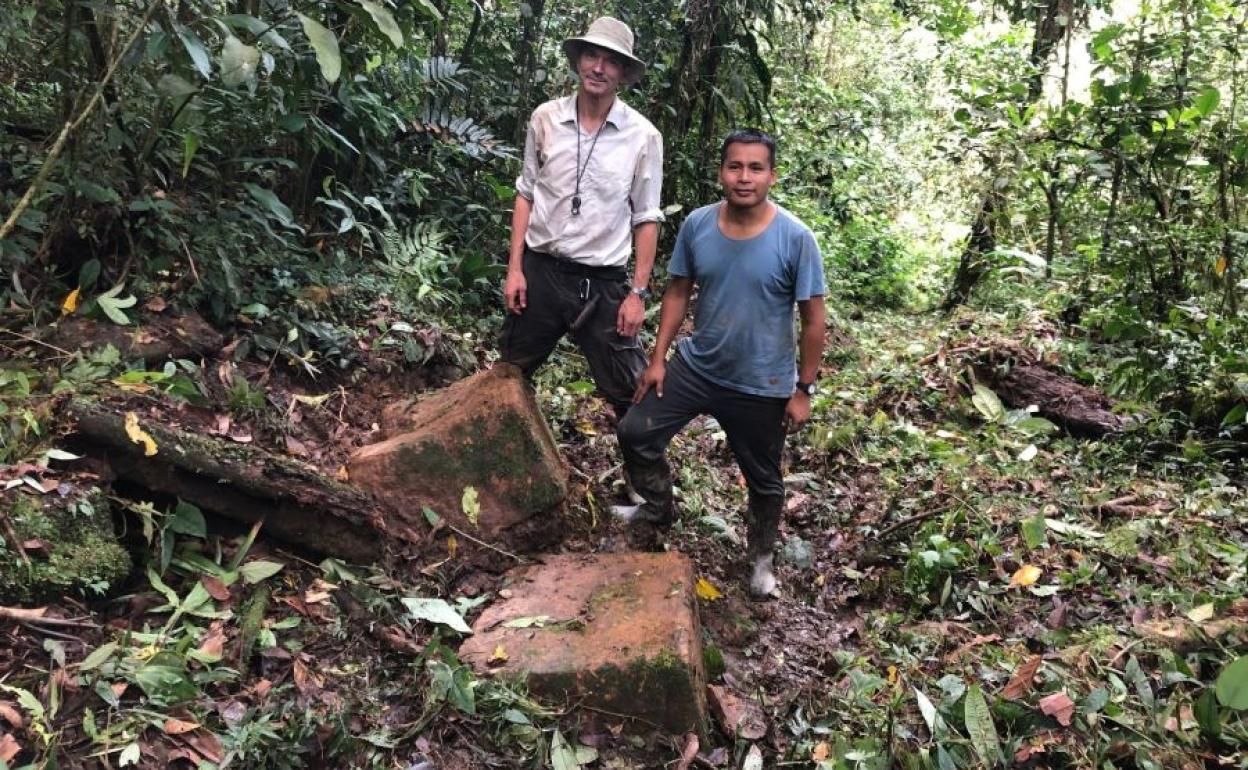 El geólogo y explorador suizo Stefan Ansermet (izda.) y su compañero ecuatoriano Faustino Tsenkush (dcha.), junto a los dos bloques de piedra en un sendero.