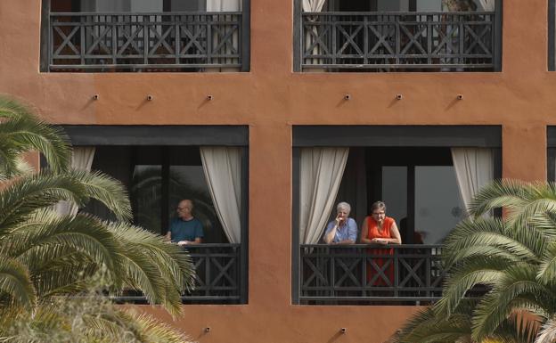 Varios turistas, en el balcón de sus habitaciones del hotel.