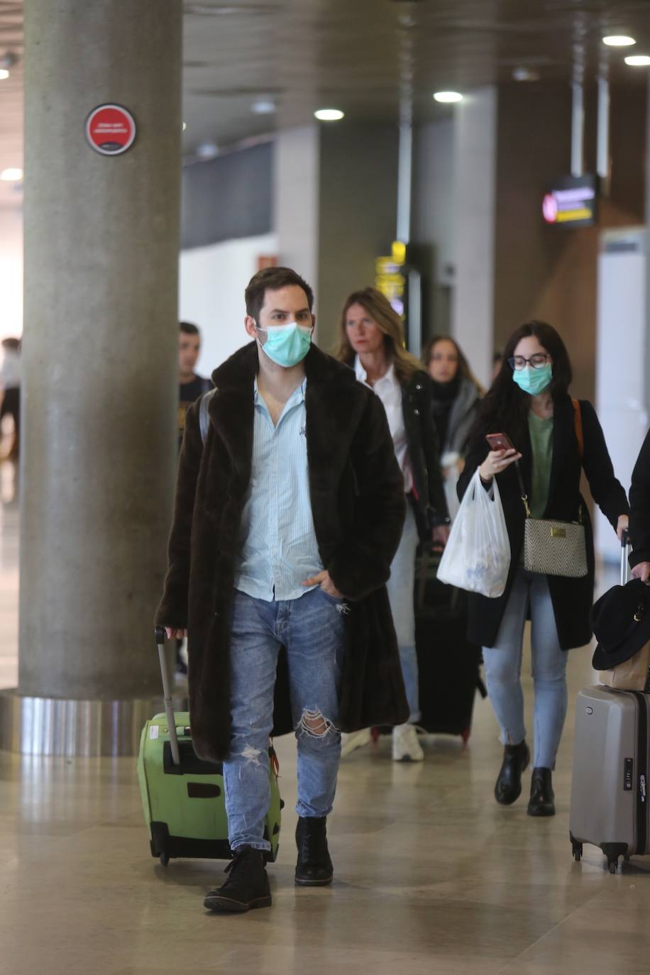 Pasajeros en el aeropuerto de Manises con mascarillas. 