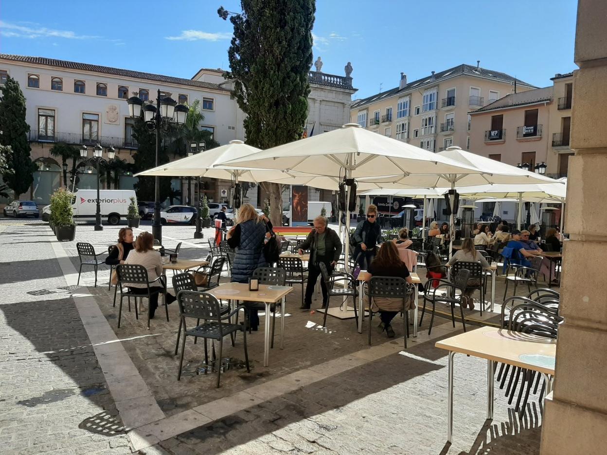 Clientes disfrutando ayer por la mañana del buen tiempo en una de las terrazas de un restaurante ubicado en la plaza Mayor de Gandia. r. escrihuela