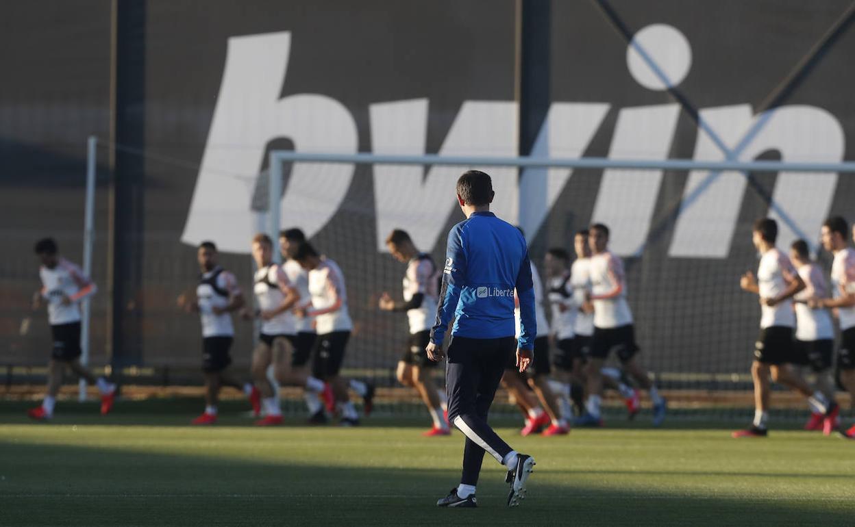 Celades observa cómo los jugadores corren en el calentamiento previo.