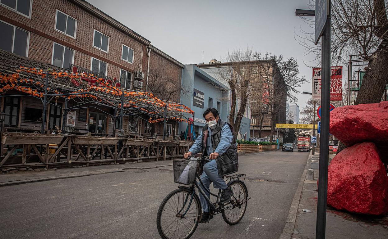 Un hombre en bicicleta en una calle de Pekín. 