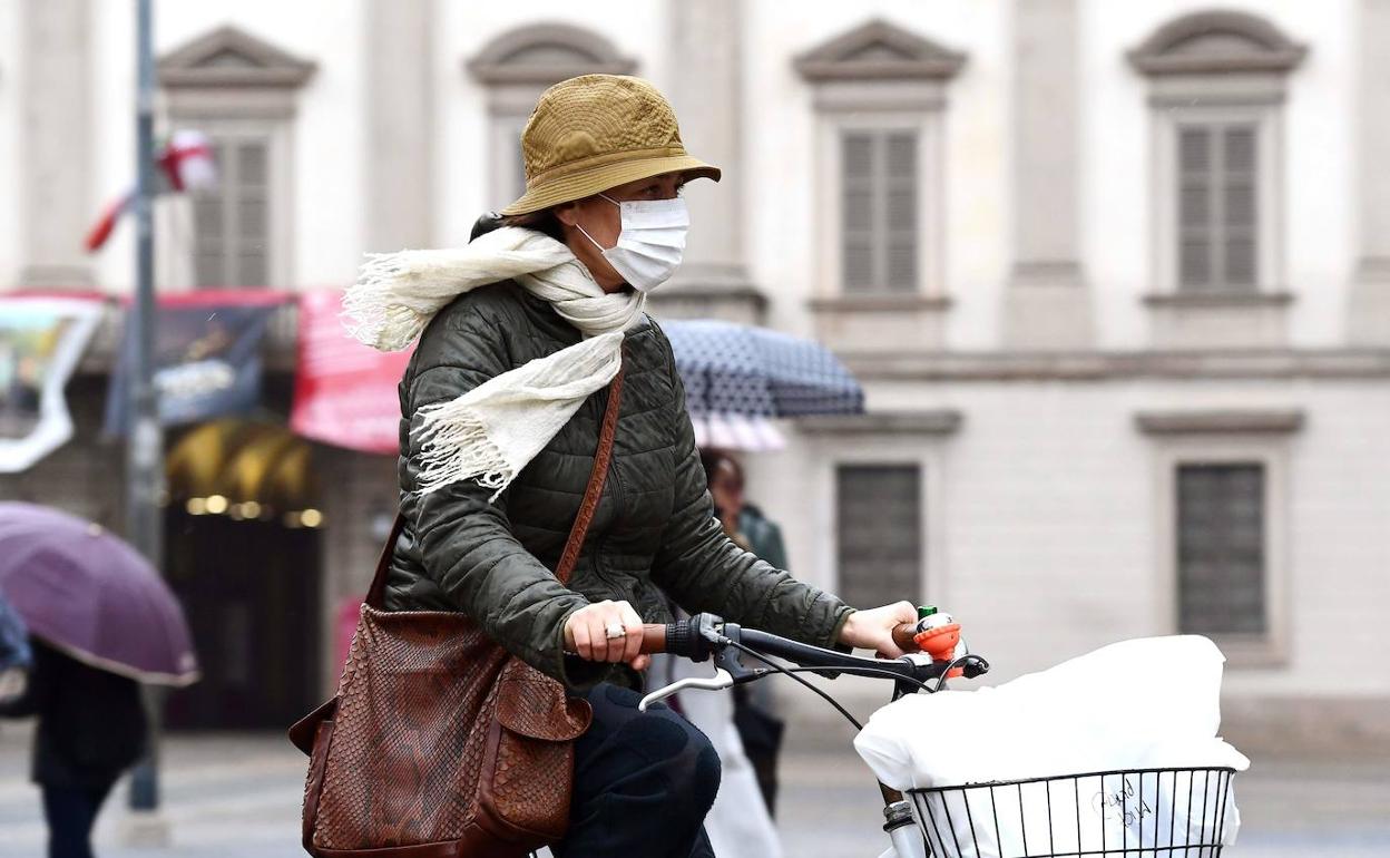 Una italiana circula en bicicleta con mascarilla. 