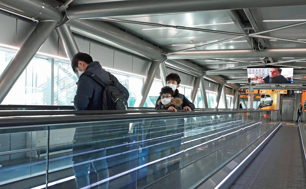 Turistas en el aeropuerto de Roma con mascarilla por el riesgo al contagio.