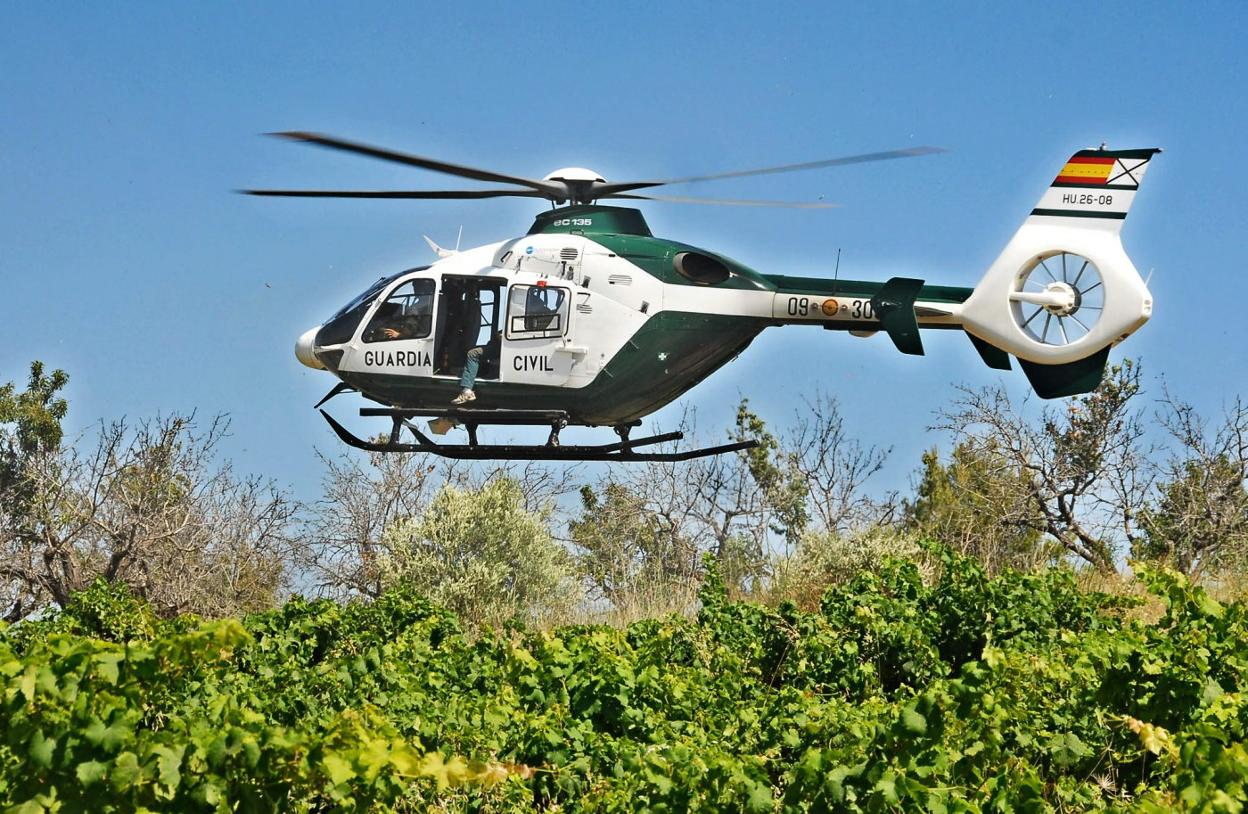 Un helicóptero de la Guardia Civil de Valencia sobrevuela un campo. josé iglesias