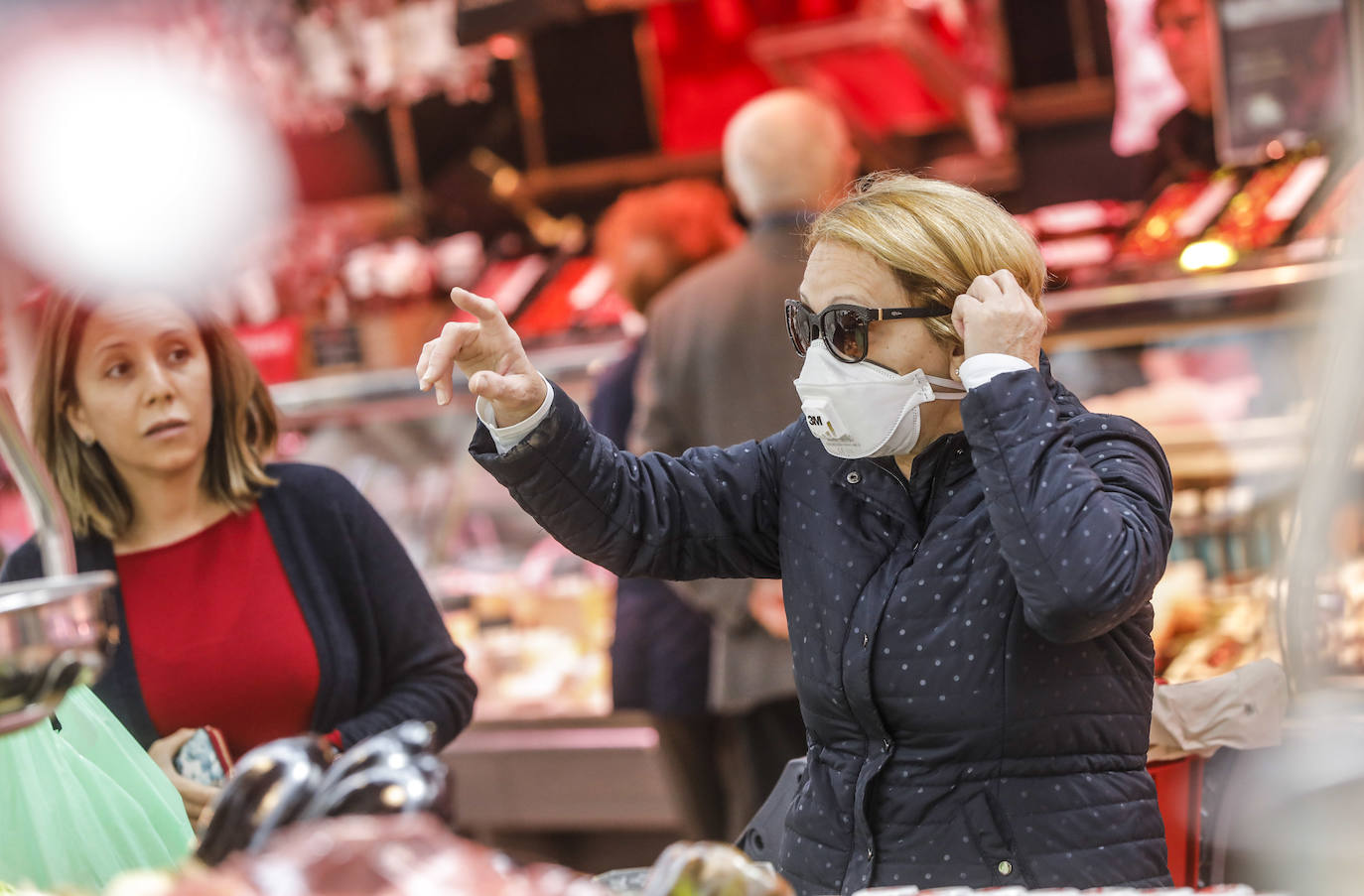 Una mujer en el Mercado Central de Valencia se protege con mascarilla. 