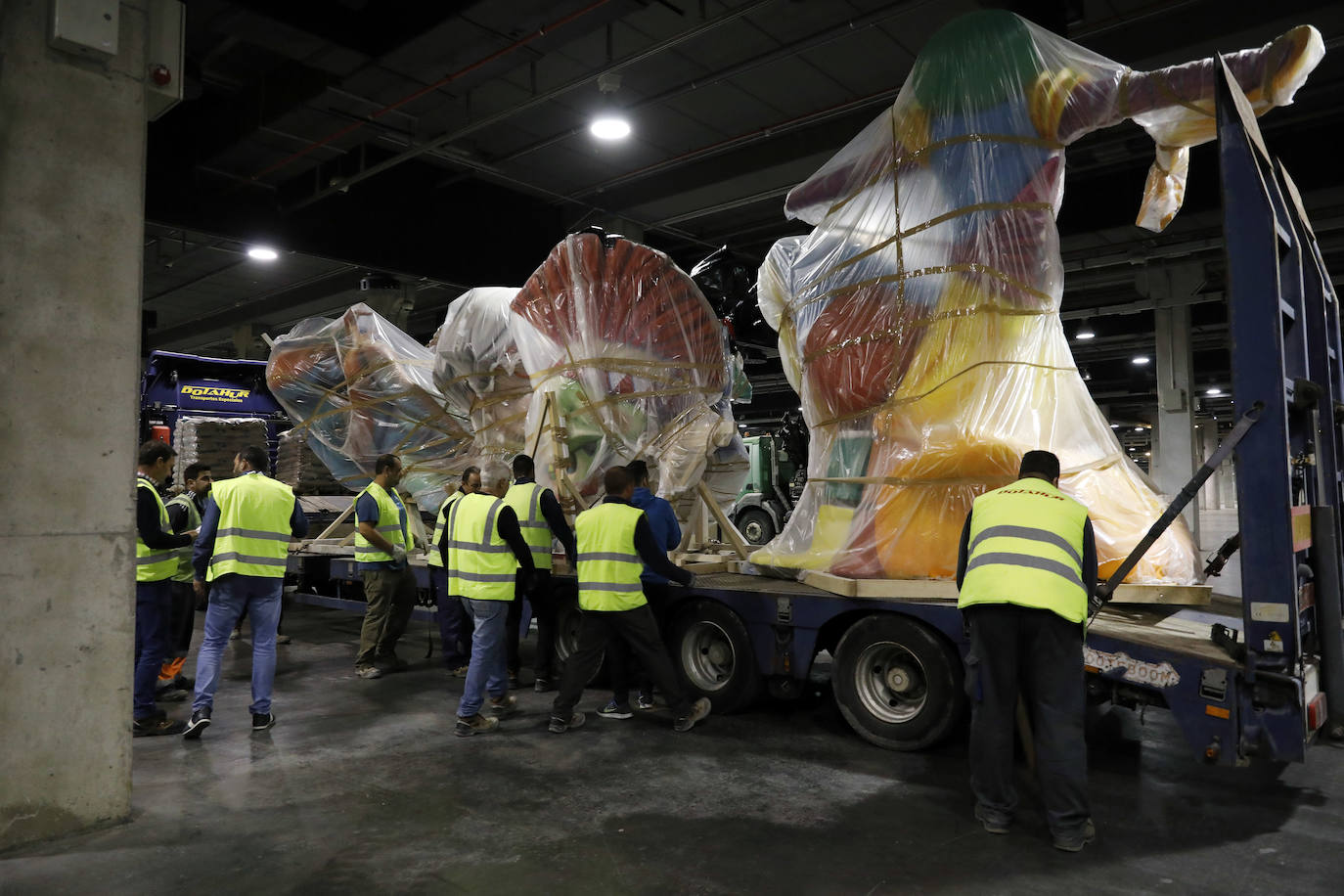 Las instalaciones de Feria Valencia han empezado a acoger, a última hora de este viernes, las piezas de distintas fallas de València que no habían sido aún plantadas en las calles y que permanecerán ahora resguardadas hasta el próximo mes de julio. Piezas de gran tamaño y de todos los colores y formas posibles han ido entrando paulatinamente a bordo de varios camiones en una de las grandes naves de Feria Valencia habilitadas expresamente para esta medida de urgencia, adoptada esta semana tras la decisión del aplazamiento de las Fallas ante la pandemia del coronavirus. Está previsto que distintas comisiones falleras lleven allí sus piezas más grandes hasta julio, cuando volverán a tomar las calles para la Plantà definitiva de los monumentos, que arderán el 19 de julio.