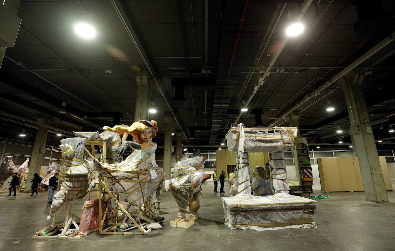 Las instalaciones de Feria Valencia han empezado a acoger, a última hora de este viernes, las piezas de distintas fallas de València que no habían sido aún plantadas en las calles y que permanecerán ahora resguardadas hasta el próximo mes de julio. Piezas de gran tamaño y de todos los colores y formas posibles han ido entrando paulatinamente a bordo de varios camiones en una de las grandes naves de Feria Valencia habilitadas expresamente para esta medida de urgencia, adoptada esta semana tras la decisión del aplazamiento de las Fallas ante la pandemia del coronavirus. Está previsto que distintas comisiones falleras lleven allí sus piezas más grandes hasta julio, cuando volverán a tomar las calles para la Plantà definitiva de los monumentos, que arderán el 19 de julio.