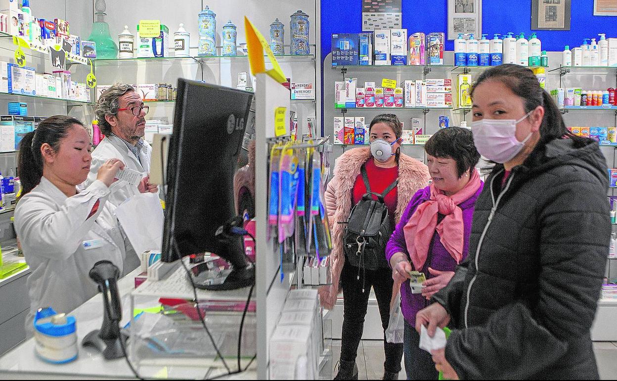 Unos farmacéuticos atienden a clientes en el barrio de Usera, en Madrid