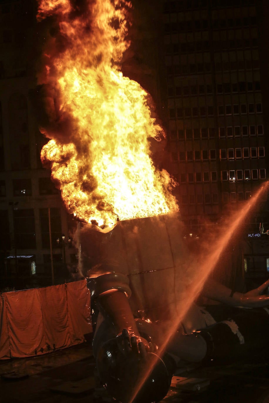 Los bomberos hacen arder la parte ya plantada de la falla del Ayuntamiento. La cabeza de la chica se guardará para la celebración de julio.