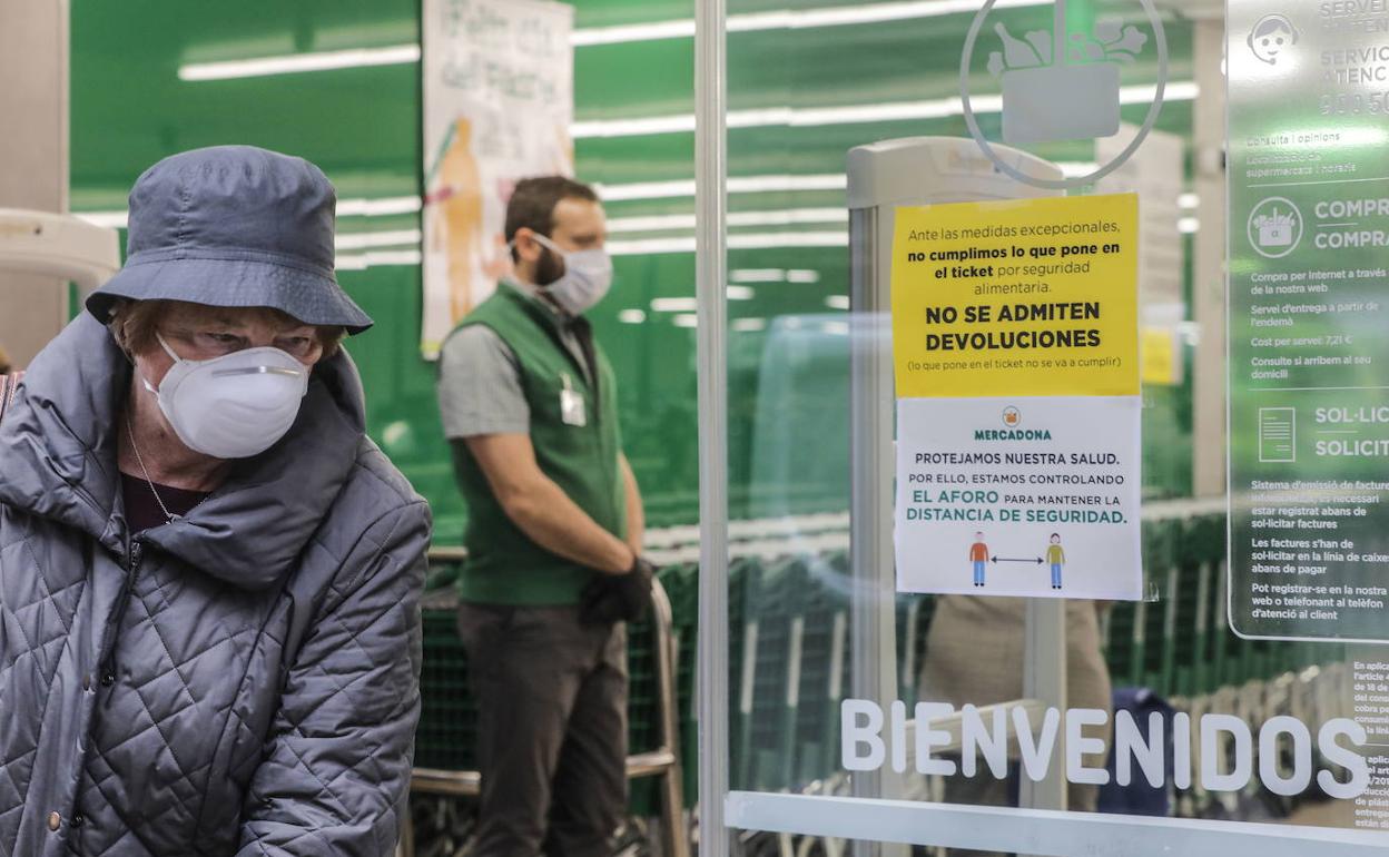 Una mujer con mascarilla a las puertas de un Mercadona. 