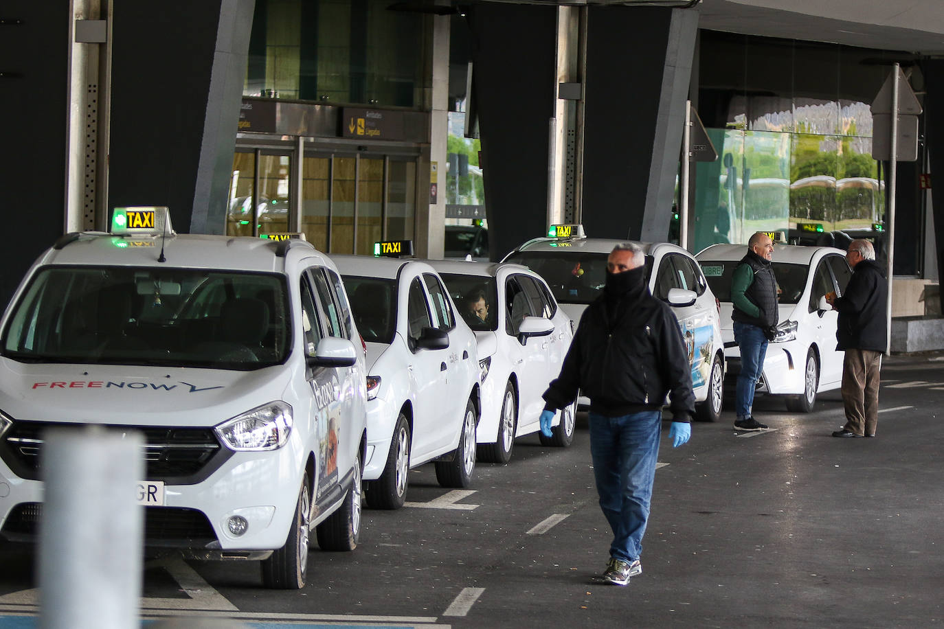 Varios taxistas esperan a recoger pasajeros en la entrada del Aeropuerto de Valencia. 