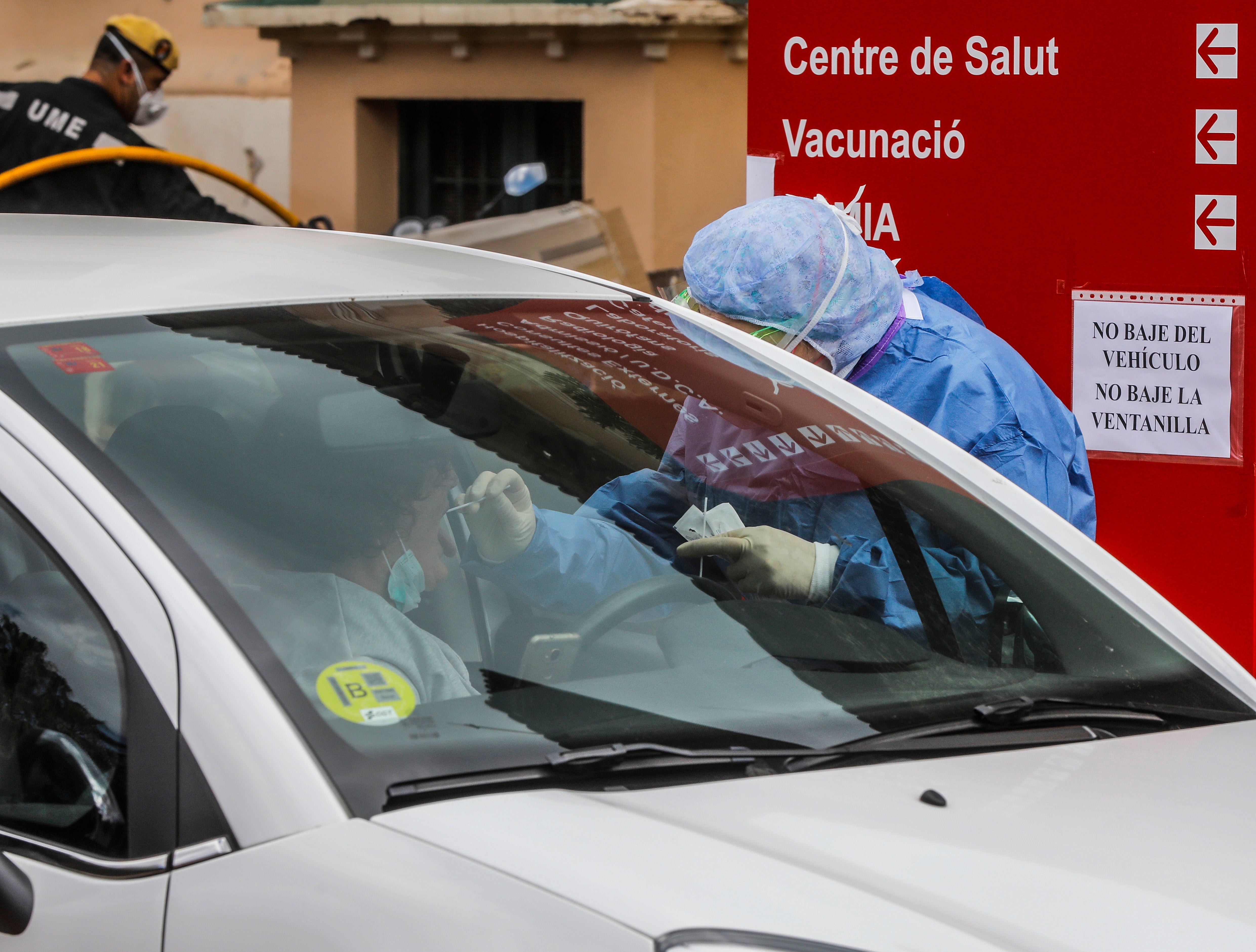 Miembros del hospital de la Malvarrosa, en Valencia, realizan tomas de muestra rápidas al personal sanitario sin que los conductores bajen del vehículo. 