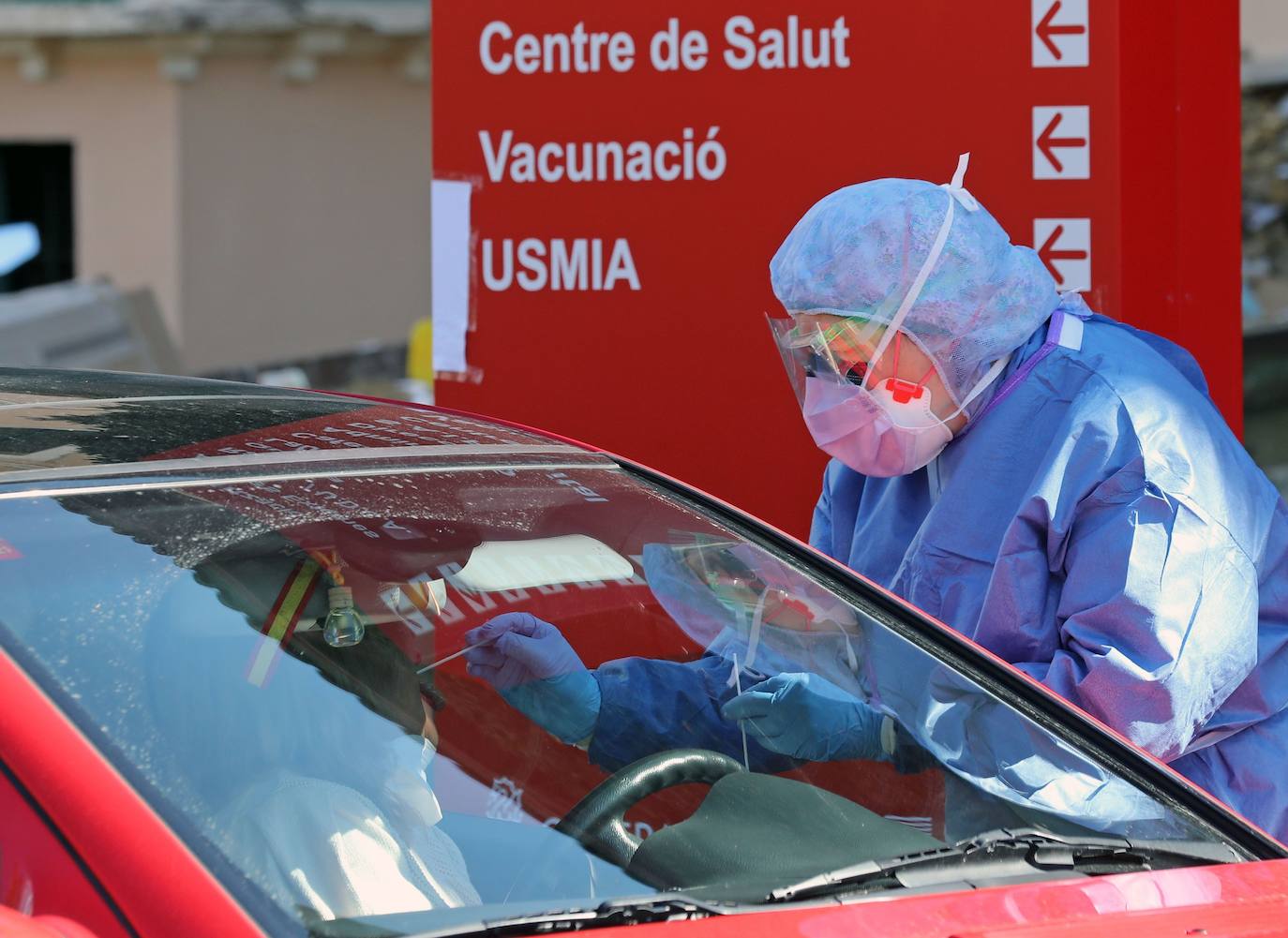 Miembros del hospital de la Malvarrosa, en Valencia, realizan tomas de muestra rápidas al personal sanitario sin que los conductores bajen del vehículo. 