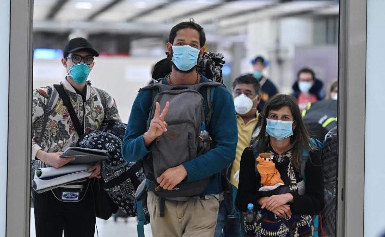 Pasajeros procedentes de Ecuador llegan al aeropuerto de Barajas en un vuelo de Iberia.