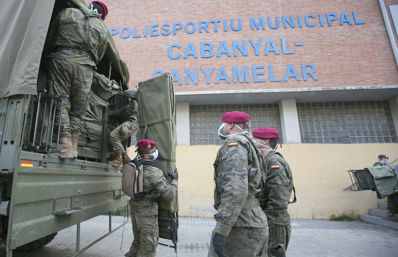 Militares del ejército colocan los materiales necesarios para adecuar el polideportivo del Cabanyal en un albergue para personas sin techo. 