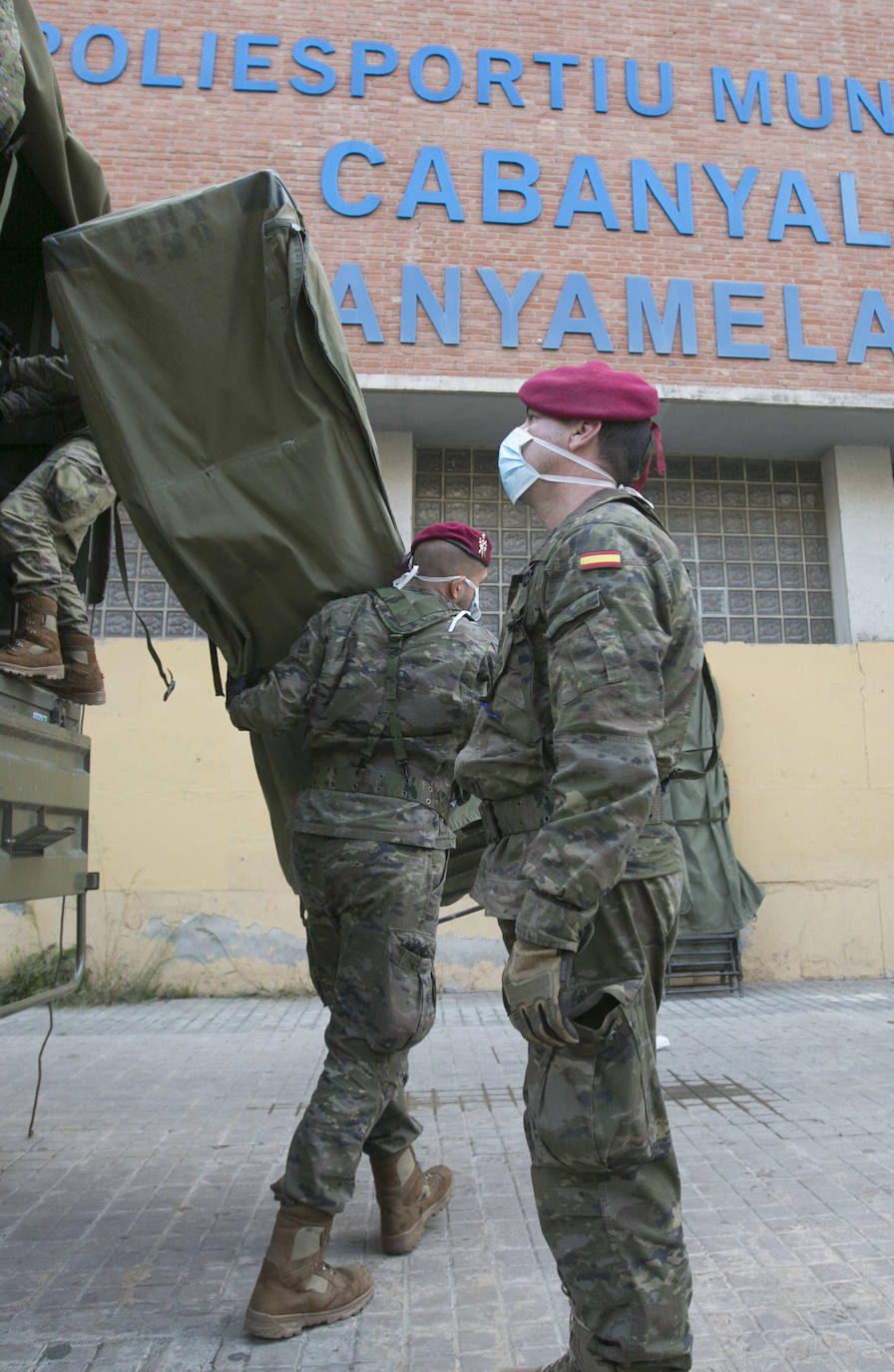 Militares del ejército colocan los materiales necesarios para adecuar el polideportivo del Cabanyal en un albergue para personas sin techo. 