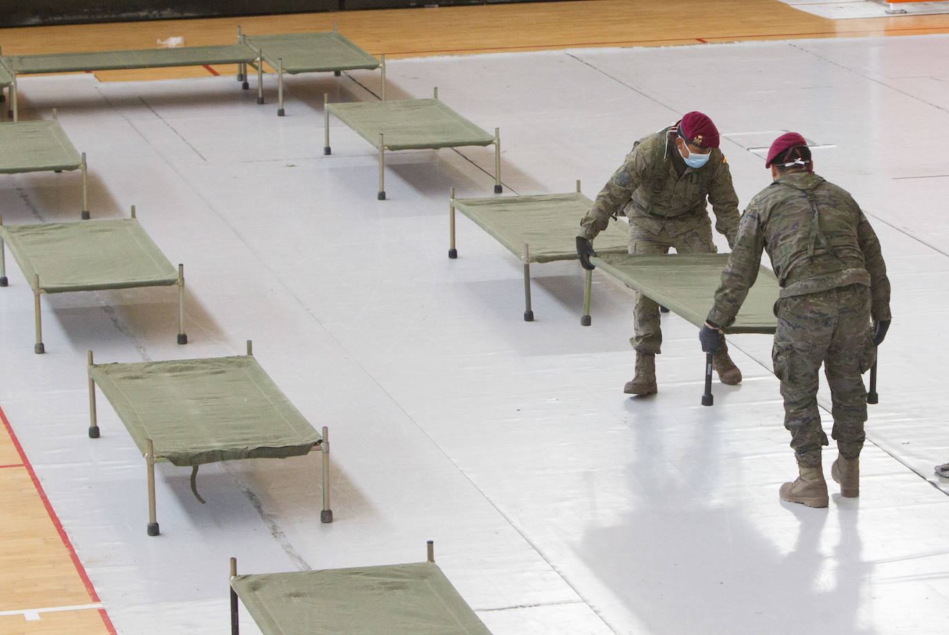 Militares del ejército colocan los materiales necesarios para adecuar el polideportivo del Cabanyal en un albergue para personas sin techo.