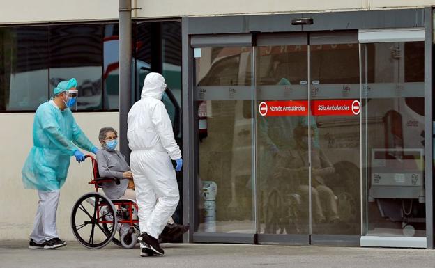 Dos profesionales sanitarios trasladan a una mujer en el Hospital La Fe de Valencia.