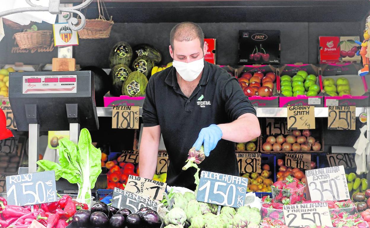 Un trabajador de un puesto del Mercado Central coloca sus productos, a la espera de clientes.