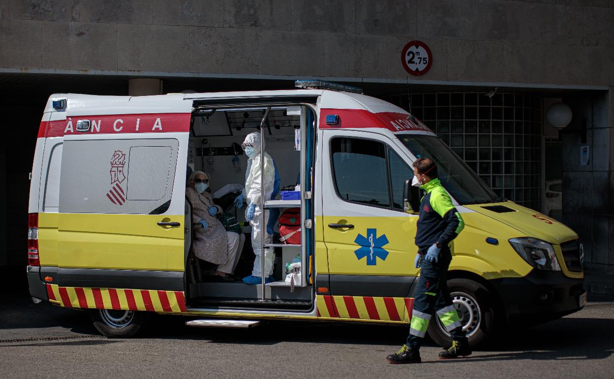 Dos sanitarios atienden a una paciente en una ambulancia. 