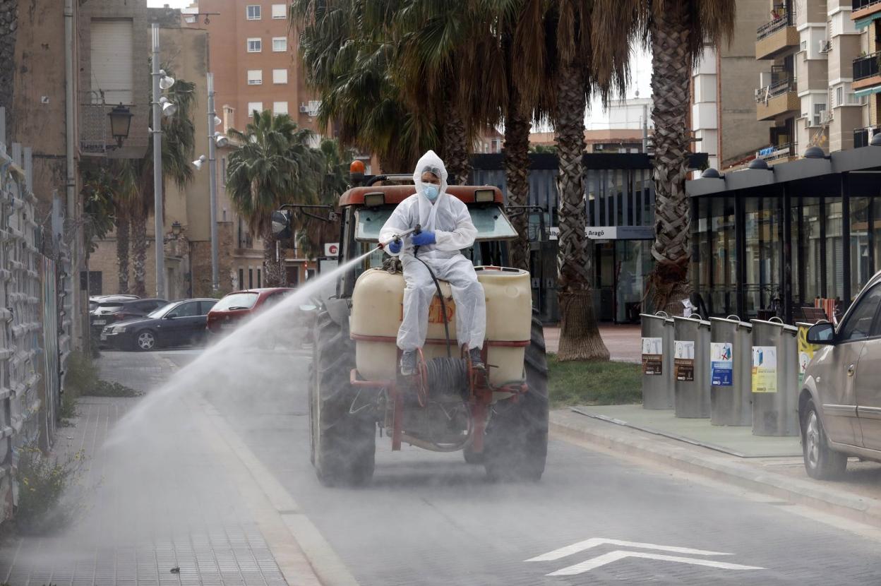 Un tractor de labores agrarias, ayer en tareas de desinfección por las calles de Alboraya. irene marsilla