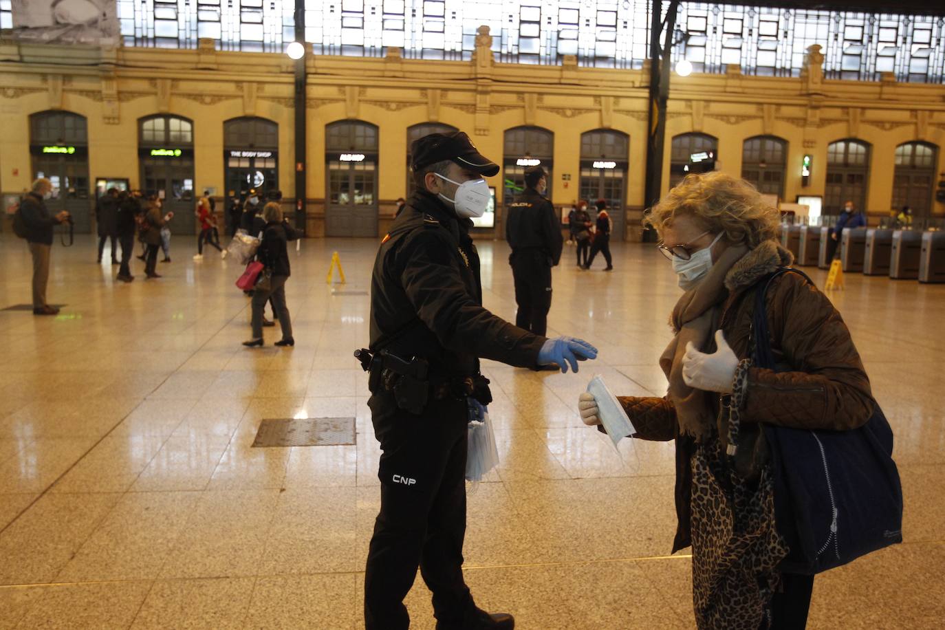 Policías y guardias civiles distribuyen mascarillas en estaciones de tren, cercanías, metros y autobuses a las personas que emplean el transporte público para acudir a sus puestos de trabajo en el primer día laborable tras la Semana Santa. 