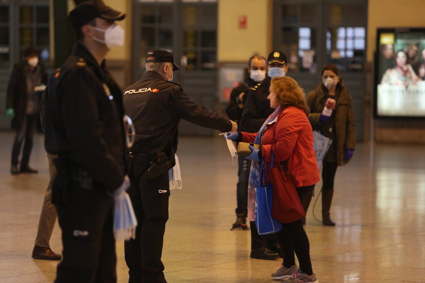 Policías y guardias civiles distribuyen mascarillas en estaciones de tren, cercanías, metros y autobuses a las personas que emplean el transporte público para acudir a sus puestos de trabajo en el primer día laborable tras la Semana Santa. 