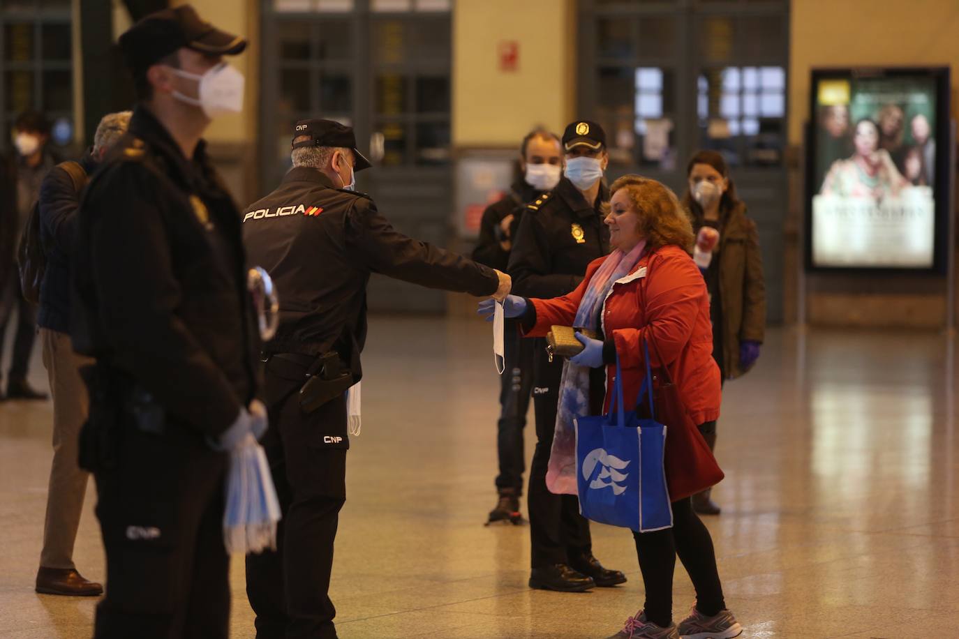 Policías y guardias civiles distribuyen mascarillas en estaciones de tren, cercanías, metros y autobuses a las personas que emplean el transporte público para acudir a sus puestos de trabajo en el primer día laborable tras la Semana Santa. 