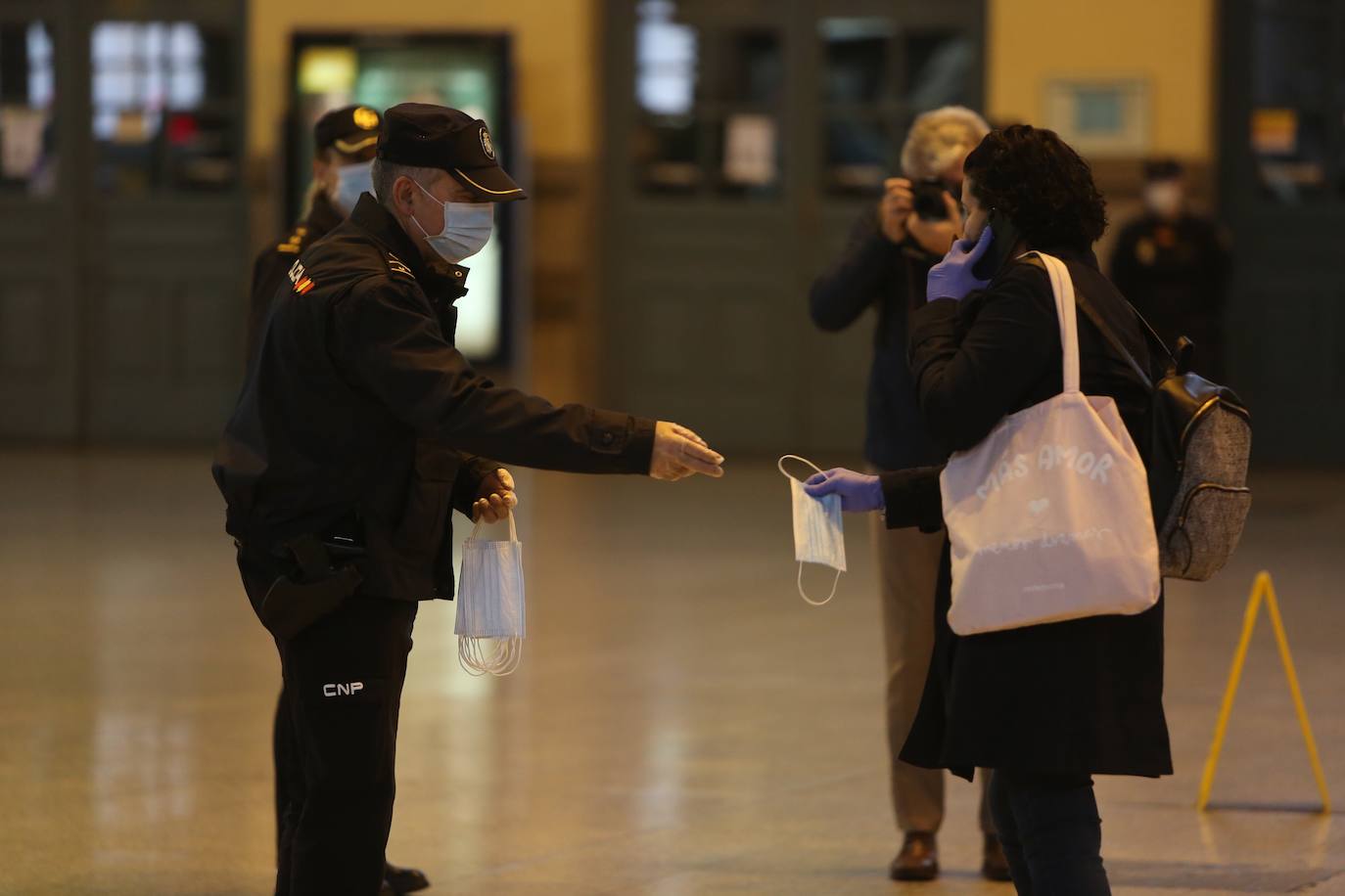 Policías y guardias civiles distribuyen mascarillas en estaciones de tren, cercanías, metros y autobuses a las personas que emplean el transporte público para acudir a sus puestos de trabajo en el primer día laborable tras la Semana Santa. 