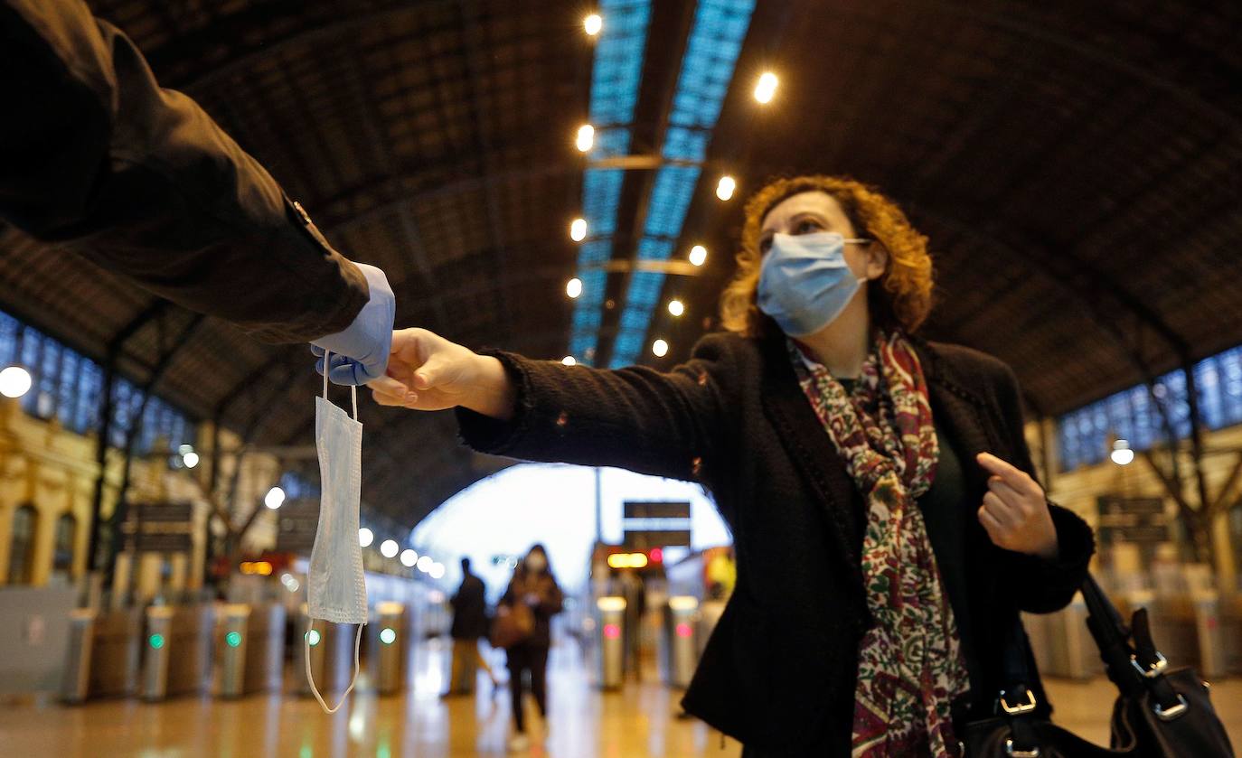 Policías y guardias civiles distribuyen mascarillas en estaciones de tren, cercanías, metros y autobuses a las personas que emplean el transporte público para acudir a sus puestos de trabajo en el primer día laborable tras la Semana Santa. 