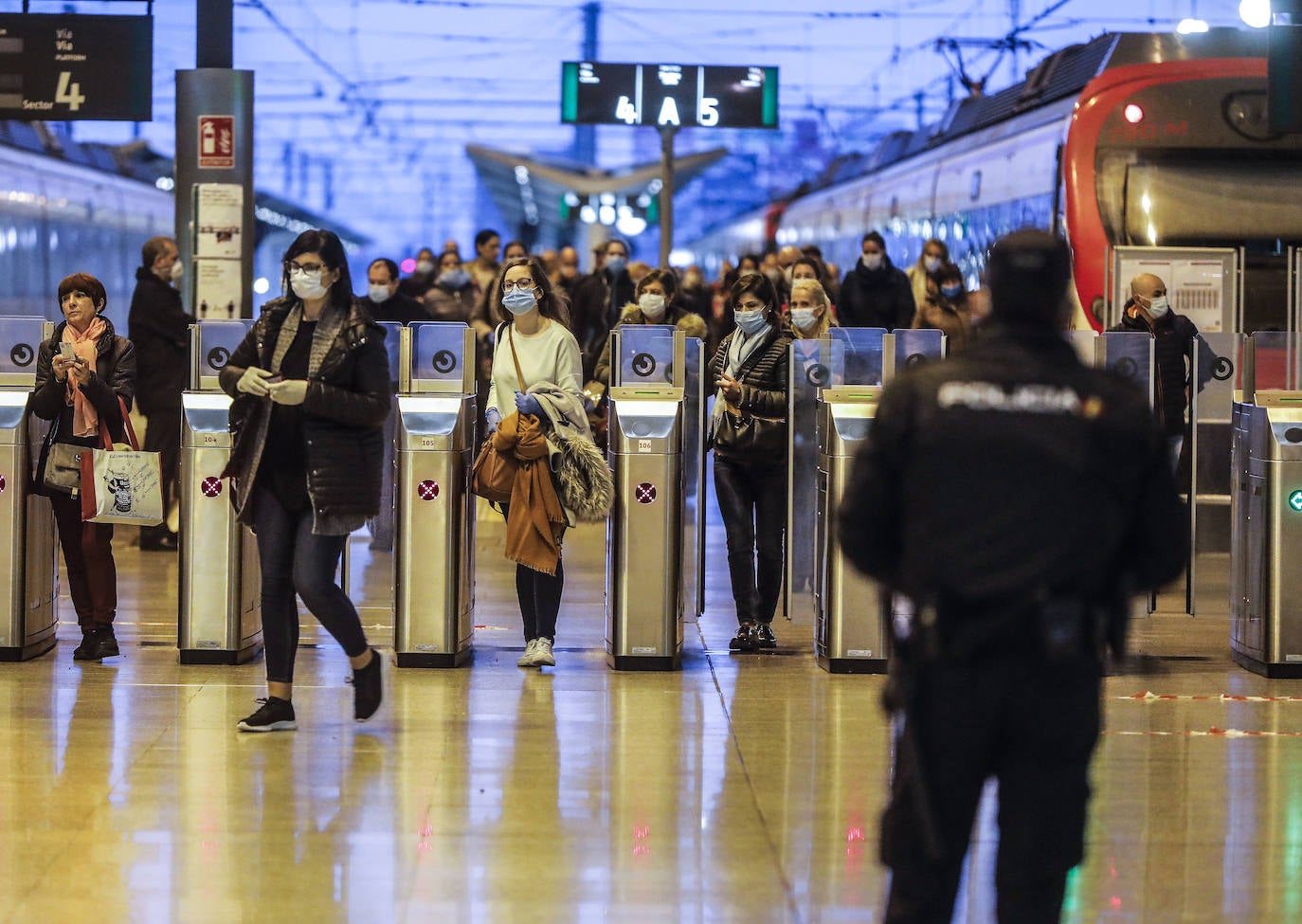 Policías y guardias civiles distribuyen mascarillas en estaciones de tren, cercanías, metros y autobuses a las personas que emplean el transporte público para acudir a sus puestos de trabajo en el primer día laborable tras la Semana Santa. 