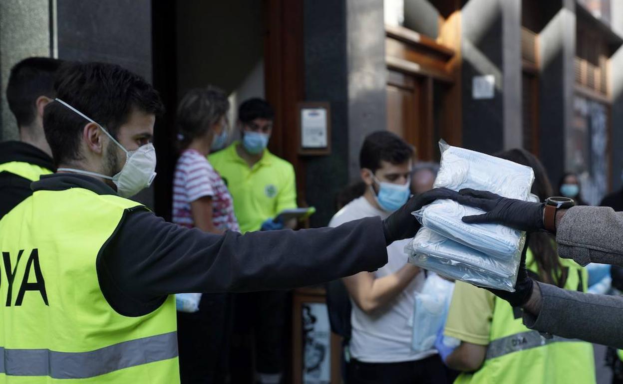 Voluntarios DYA reparten mascarillas entre las población.