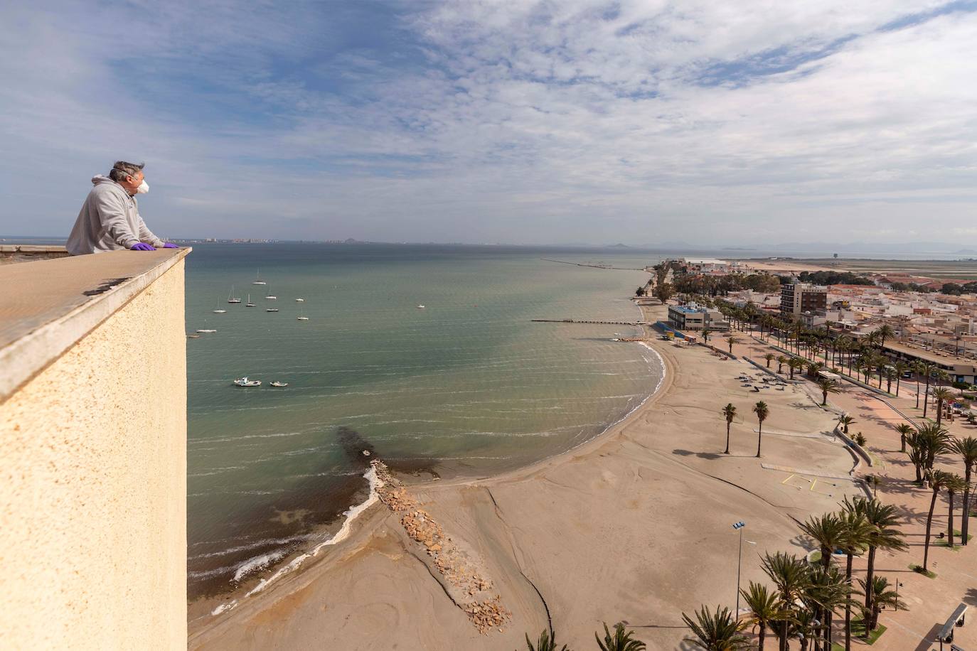 Un vecino de Santiago de la Ribera, Murcia, observa desde la terraza de su vivienda la playa desierta de Barnuevo. 