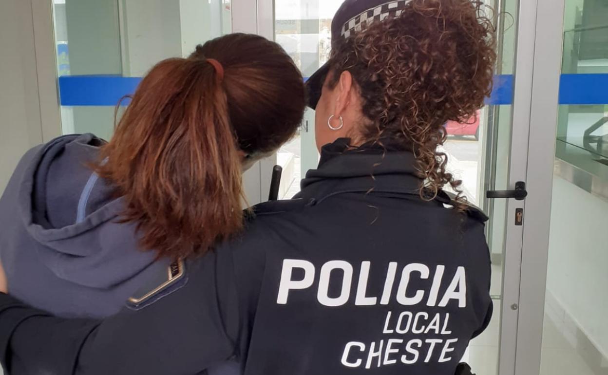 Una policía local de Cheste atiende a una mujer. 