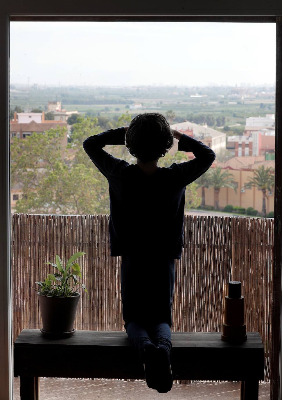 Un niño contempla el exterior desde su casa, en Godella