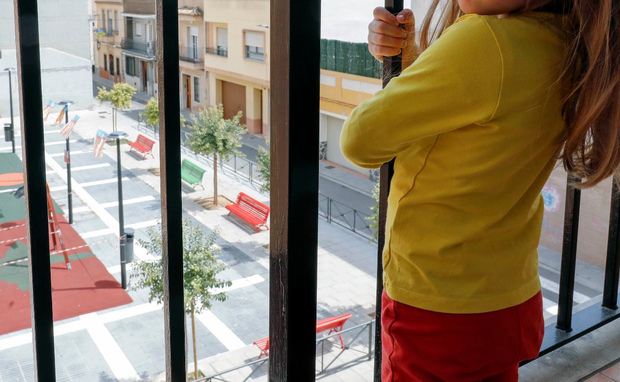 Victoria se asoma al balcón mirando al parque de debajo de su casa. 