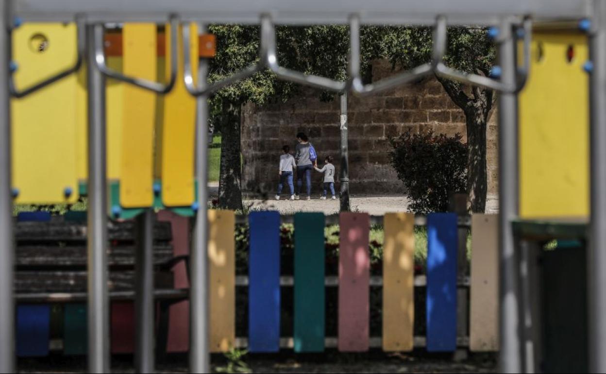 Una madre con sus dos hijos en un parque de Valencia.