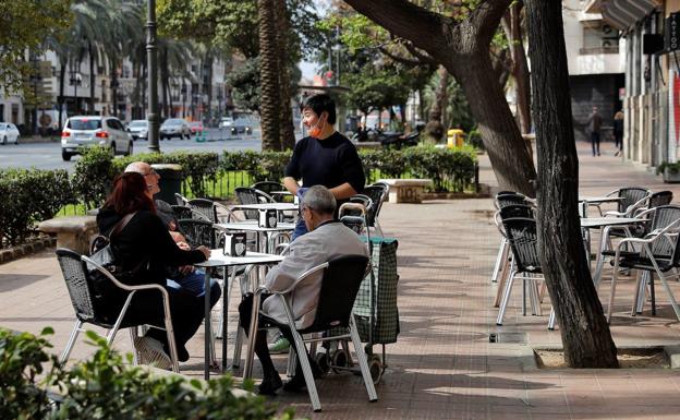 Un camarero atiende a una mesa en una terraza de Valencia.